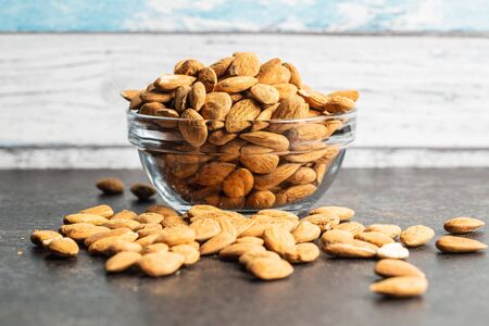 Dried almond nuts in bowl on kitchen table.