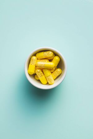Vitamin capsules. Vitamin C pills in bowl on colorful background. Top view.の写真素材