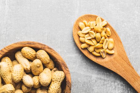 Roasted salted peanuts. Crispy nuts in wooden spoon. Top view.