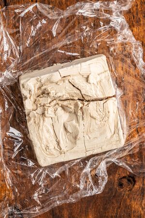 Fresh yeast blocks on wooden table. Top view.