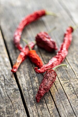 Dried red chili peppers on wooden table.の写真素材