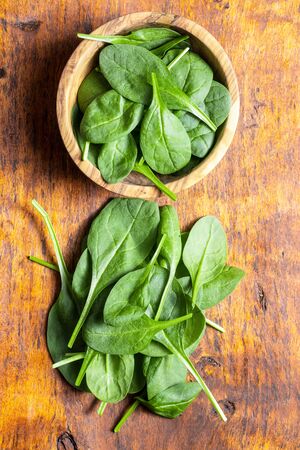 Baby spinach leaves. Green spinach on wooden table. Top view.の写真素材