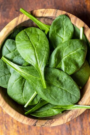 Baby spinach leaves. Green spinach in bowl. Top view.の写真素材