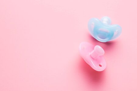 Silicone pacifier. Pink and blue baby pacifier on pink background.の写真素材