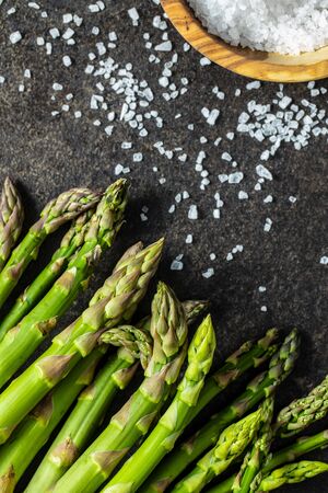 Fresh green asparagus. Healthy seasonal vegetable on black table. Top view.の写真素材