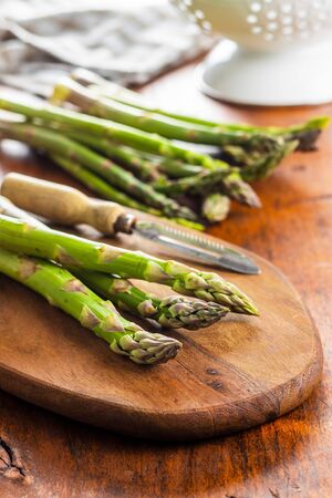 Fresh green asparagus. Healthy seasonal vegetable on cutting board.の写真素材