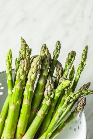 Fresh green asparagus. Healthy seasonal vegetable in colander.の写真素材