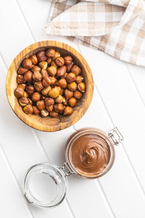 Sweet hazelnut spread. Chocolate cream in jar on white table. Top view.の写真素材