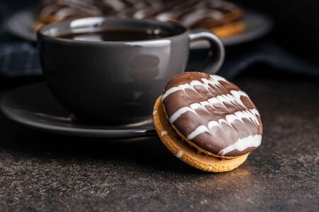 Sweet dessert with chocolate cream and chocolate icing on black kitchen table.の写真素材
