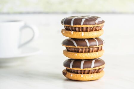 Sweet dessert with chocolate cream and chocolate icing on white kitchen table.の写真素材