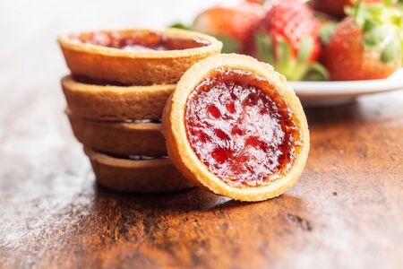 Sweet biscuits with strawberries jam on wooden table.の写真素材