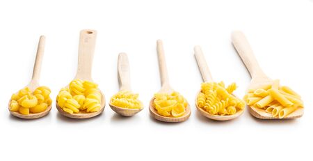 Various types of raw italian pasta  in wooden spoons isolated on white background.の写真素材