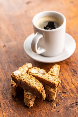 Sweet italian cantuccini cookies. Almonds biscuits with coffee cup on wooden table.の写真素材