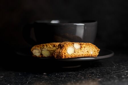 Sweet italian cantuccini cookies. Almonds biscuits on black plate.の写真素材
