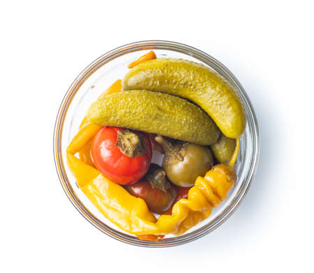 Pickled chili peppers and pickles in bowl isolated on white background.の写真素材