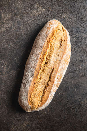 Crusty homemade bread on black table. Top view.