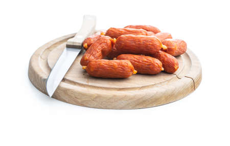 Mini salami sausages on wooden cutting board isolated on white background.の写真素材