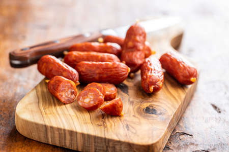 Sliced mini salami sausages on cutting board.の写真素材