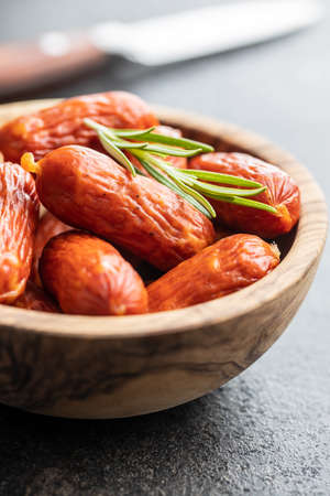 Mini salami sausages in bowl on black table.の写真素材