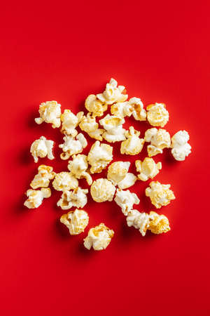 Sweet tasty popcorn on red background. Top view.