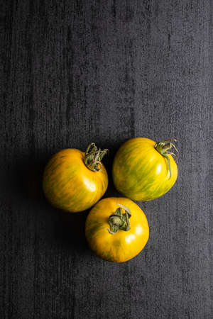 Green zebra tomatoes on black table. Top view.の写真素材
