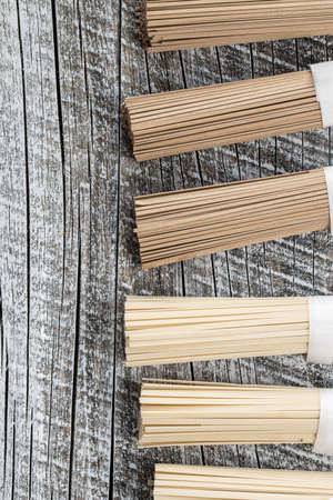 Uncooked soba and udon noodles on wooden table. Traditional Japanese noodles. Top view.の写真素材