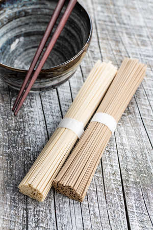 Uncooked soba and udon noodles. Traditional Japanese noodles on wooden table.の写真素材