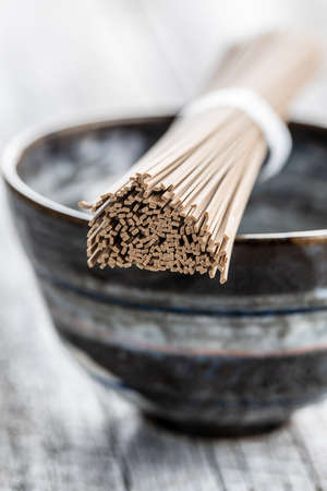 Uncooked room noodles. Traditional Japanese noodles on bowl.