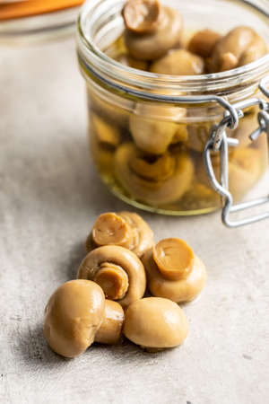 Pickled champignons. Marinated mushrooms on kitchen table.の写真素材
