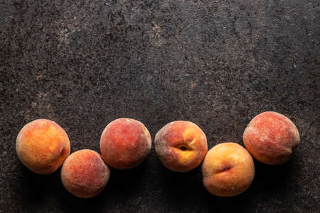 Fresh ripe organic peaches on black table. Top view.の写真素材