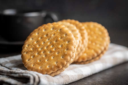 Sweet sandwich cookies on checkered napkin.
