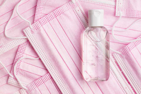 Antibacterial hand gel and pink face masks. Top view.の写真素材