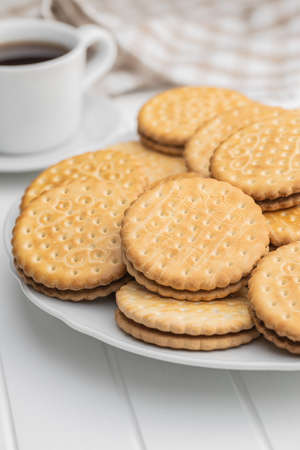 Sandwich cookies on plate. Sweet biscuits with cream on white table.の写真素材