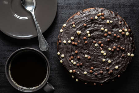 Sweet chocolate cake on black table. Top view.