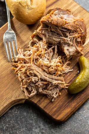 Pulled pork meat on cutting board.