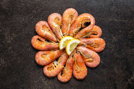 Boiled tiger prawns on black table. Top view. Tasty shrimps.