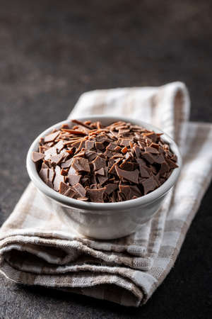 Grated dark chocolate. Chocolate flakes in bowl on checkered napkin.の写真素材