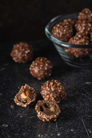 Sweet chocolate truffles. Tasty belgian pralines balls on black table.