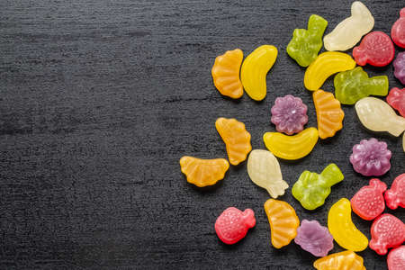 Colorful fruity jelly candies on black table. Top view.の写真素材