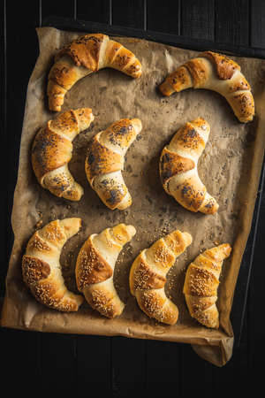 Salted croissant bun roll on a baking paper. Homemade pastry. Top view.の写真素材