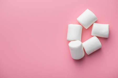 White sweet marshmallows candy on pink background. Top view.