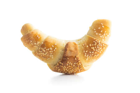 Salted croissant bun roll with sesame seeds. Homemade pastry isolated on white background.