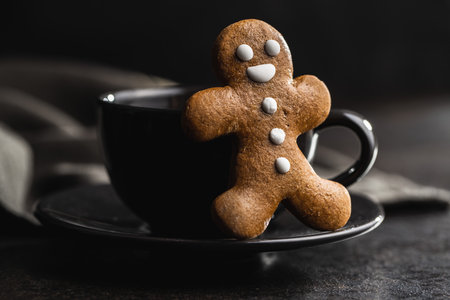 Xmas gingerbread man and coffee cup on black table.の写真素材