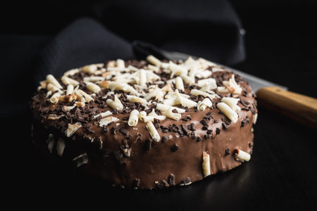 Sweet chocolate pie. Cake with chocolate sprinkles on black table.の写真素材