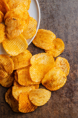 Crispy potato chips on a brown table.