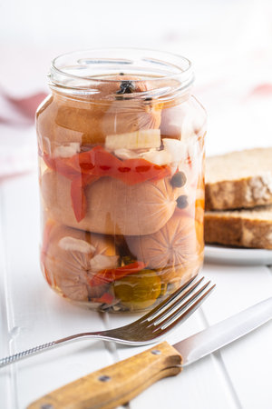 Pickled sausages with onion and red pepper. Marinated food in jar.の写真素材