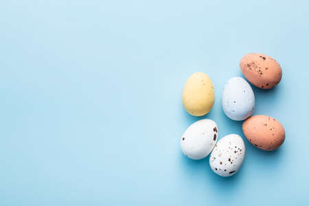 Colorful chocolate easter eggs. Sweet candy eggs on a blue background. Top view.