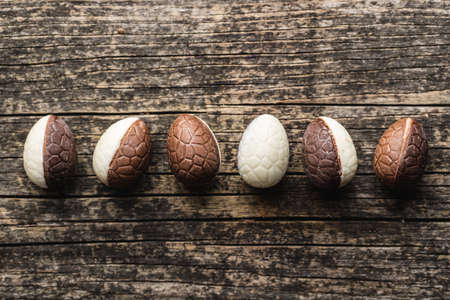 Chocolate easter eggs. Sweet candy eggs on a wooden table. Top view.