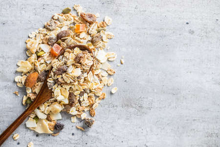Beakfast cereals. Healthy muesli with oat flakes, nuts and raisins. Top view.の写真素材