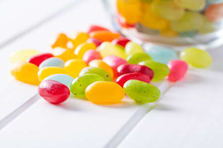 Sweet colorful jelly beans on white table.